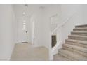 A bright foyer with tile flooring, a staircase, and a view of the front door at 12123 Glentana View St, Las Vegas, NV 89138