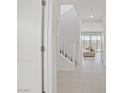 Bright hallway featuring tile flooring and a staircase leading to the upper level, with an inviting living space beyond at 12123 Glentana View St, Las Vegas, NV 89138