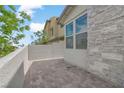 A stone patio with modern, neutral-colored walls, offering a private outdoor space at 12123 Glentana View St, Las Vegas, NV 89138