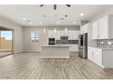 Open-concept kitchen with a center island, stainless steel appliances, and a sliding glass door to the back patio at 12550 Point Sierra St, Las Vegas, NV 89138