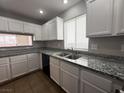 Galley style kitchen featuring granite countertops, tile floors, and white cabinetry at 2105 William Holden Ct, Las Vegas, NV 89142