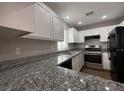 Modern kitchen with stainless steel appliances, granite countertops, and white cabinets at 2105 William Holden Ct, Las Vegas, NV 89142
