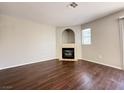 Spacious living room with hardwood floors featuring a tile fireplace, window, and gray painted walls at 2105 William Holden Ct, Las Vegas, NV 89142