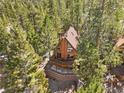 A-frame cabin nestled in lush greenery featuring a spacious deck perfect for enjoying the mountain scenery at 2160 Via Vita St, Mount Charleston, NV 89124