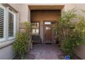 Inviting front porch with brick pavers, lush greenery, and a charming wooden bench at 240 Jumping Springs Pl, Henderson, NV 89012