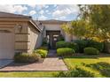 Lovely home with a well-kept lawn, mature trees, and a welcoming brick pathway at 240 Jumping Springs Pl, Henderson, NV 89012