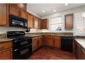 Well-equipped kitchen featuring wooden cabinets, granite countertops, and modern black appliances at 240 Jumping Springs Pl, Henderson, NV 89012