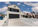 Two-story home featuring a black garage door, tiled roof, and desert landscaping at 2712 Sidonia Ave, Las Vegas, NV 89102