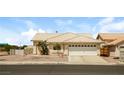 Inviting one-story home with a neutral-colored exterior, desert landscaping, and an attached garage at 3214 W Gilmore Ave, North Las Vegas, NV 89032