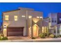 Well-lit two-story home at dusk featuring a two-car garage, welcoming entryway, and modern design at 3216 Monte Luna Ave, Henderson, NV 89044