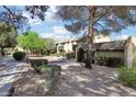 Picturesque exterior view showcasing charming townhome with mature trees, landscaping, and walkway at 3233 Kinsale Ct, Las Vegas, NV 89121