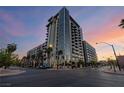An eye-level exterior shot of a high-rise apartment building, featuring palm trees and street lights at 353 E Bonneville Ave # 632, Las Vegas, NV 89101