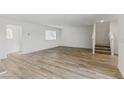 Spacious living room with hardwood floors, bright white walls, and staircase at 6850 Magenta Moon St, North Las Vegas, NV 89086
