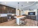 Modern kitchen with dark cabinets, stainless steel appliances, and a stylish island with seating at 7732 Canon Walk St, Las Vegas, NV 89139