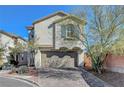 Two-story home showcasing detailed garage doors, desert landscaping and clean architectural lines at 7870 Formitch Ct, Las Vegas, NV 89166