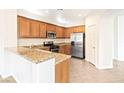 Well-lit kitchen boasts wood cabinets, stainless steel appliances, and granite countertops at 7941 Limestone Arch Ave, Las Vegas, NV 89178