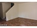 Comfortable living room with tile floors, staircase, and ample space for furniture at 10021 Via Toro Ave, Las Vegas, NV 89117