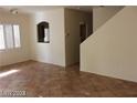 Sunlit living room with tile floors, neutral walls, and an arched opening to the kitchen at 10021 Via Toro Ave, Las Vegas, NV 89117