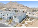 Aerial view of a modern two-story home in a desert community with mountain views and desert landscaping at 11800 Black Canary Ave, Las Vegas, NV 89138