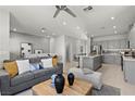 Open concept living room and kitchen with grey furniture, decor, and stainless steel appliances at 147 Harmonica Ave # Lot 24, Henderson, NV 89015