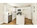 Modern white kitchen with stainless steel appliances and a breakfast bar island at 1724 Navajo Lake Way, Las Vegas, NV 89128