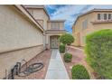 Inviting home entrance with a walkway and manicured landscaping at 1733 Gentle Brook St, North Las Vegas, NV 89084