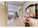 Elegant foyer with tiled floors, a decorative mirror, and a glimpse into the living room at 2377 Baldwinville Ct, Henderson, NV 89044