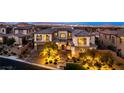 Elegant two-story home with manicured landscaping and illuminated driveway; luxurious curb appeal at 26 Olympia Outlook Dr, Las Vegas, NV 89141