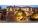 Grand two-story home with stone accents, dual garages, and professionally lit landscaping at 26 Olympia Outlook Dr, Las Vegas, NV 89141
