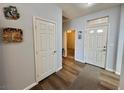 Bright hallway with wood flooring and access to rooms, showcasing the home's layout at 3263 Quail Song Dr, Laughlin, NV 89029