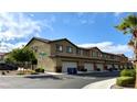 View of townhome exteriors featuring attached garages and well-maintained landscaping at 6247 Milford Sound St, Las Vegas, NV 89148