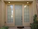 Inviting entryway with a sage-green door flanked by sidelight windows at 7649 Slide Rock Ave, Las Vegas, NV 89113