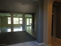 Open-concept living room featuring tile flooring, arched openings, and lots of natural light at 7649 Slide Rock Ave, Las Vegas, NV 89113
