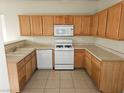 Galley kitchen showcasing wood cabinets, laminate countertops, and white appliances at 7971 Duneville St, Las Vegas, NV 89139