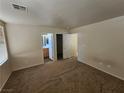 Vacant primary bedroom featuring neutral walls and carpeting with a partial view of the ensuite bathroom at 7971 Duneville St, Las Vegas, NV 89139