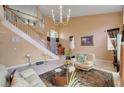 Bright living room boasts a winding staircase, elegant chandelier, and an open, airy atmosphere at 8983 Emerald Waters Ct, Las Vegas, NV 89147