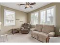 Comfortable living room features a ceiling fan, two windows with louvers, and neutral tones at 10191 Deerfield Beach Ave # 202, Las Vegas, NV 89129