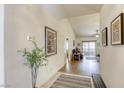 Inviting hallway with tile flooring and decorative art leads to the living room with hardwood floors at 10553 Pine Pointe Ave # 203, Las Vegas, NV 89144