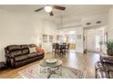 Bright living room boasts hardwood floors, ceiling fan, and open layout into the dining area and kitchen at 10553 Pine Pointe Ave # 203, Las Vegas, NV 89144