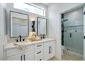 Modern bathroom with double vanity, black hardware, large mirror and glass enclosed shower at 10709 Hunters Woods Pl, Las Vegas, NV 89134