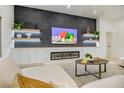 Bright living room featuring a sleek fireplace, a large sectional, and a stylish entertainment area with modern decor at 10709 Hunters Woods Pl, Las Vegas, NV 89134