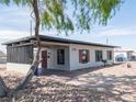 Side view of a gray home with red shutters, featuring a carport, and rock landscaping at 170 Copper St, Henderson, NV 89015