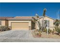 A tan single-story home featuring a two-car garage and desert landscaping at 2167 Shadow Canyon Dr, Henderson, NV 89044