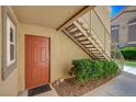 Charming entryway featuring a red door, landscaped surroundings, and convenient stair access at 2300 E Silverado Ranch Blvd # 1123, Las Vegas, NV 89183