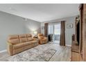 Comfortable living room with tan leather sofa, neutral walls, and sliding glass doors at 2300 E Silverado Ranch Blvd # 1123, Las Vegas, NV 89183