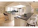 Bright kitchen with white cabinetry, granite countertops, bar seating, and modern appliances at 2747 Paradise Rd # 1703, Las Vegas, NV 89109