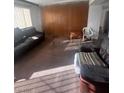 Spacious living room with older furniture and a large window providing natural light at 2820 Fort Sumter Dr, North Las Vegas, NV 89030