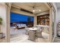 Inviting outdoor space with a kitchen, hot tub, comfortable seating, and city views at 3000 Dusky Willow Ln, Las Vegas, NV 89138
