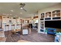 Open-concept living area with wood floors, bar seating, and built-in shelving at 4134 Riva De Tierra Ln, Las Vegas, NV 89135