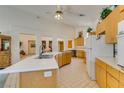 Spacious kitchen featuring wooden cabinets, tile flooring, a curved island, and modern appliances at 4765 N Grand Canyon Dr, Las Vegas, NV 89129